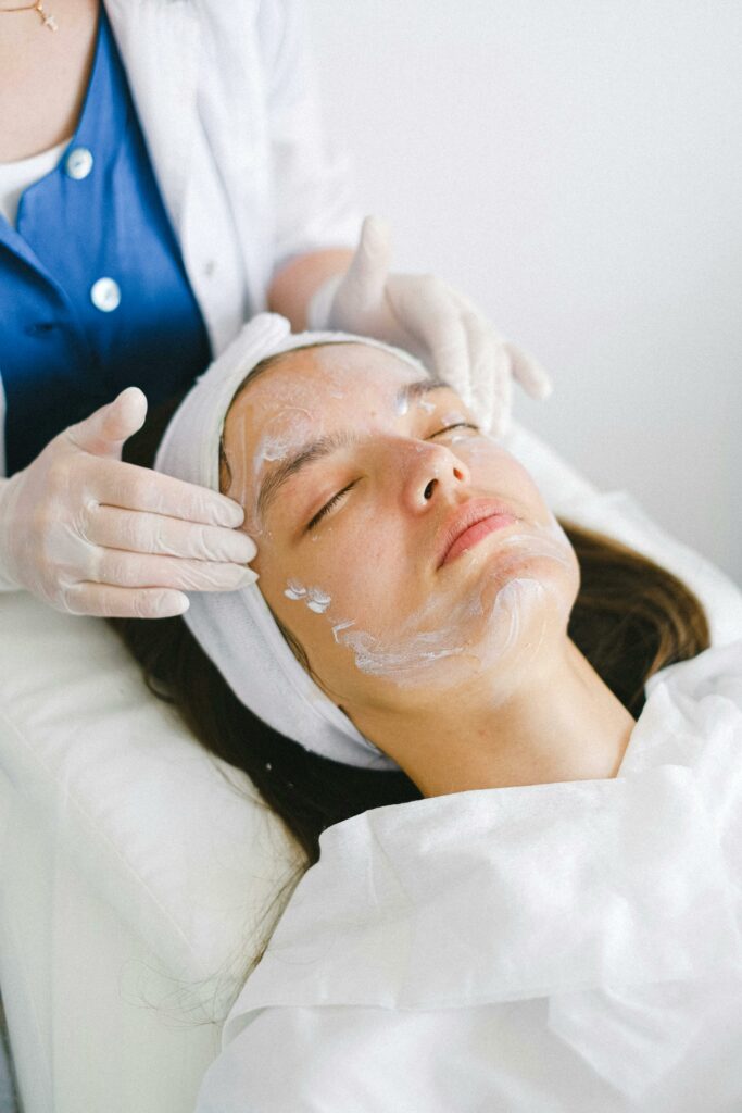 Woman relaxing while receiving a rejuvenating facial treatment.